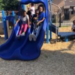 children on a blue plastic slide